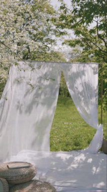 Sakin bir açık alan, rüzgarda sallanan beyaz perdeleri, canlı yeşilliklerle çevrili..