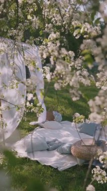 Yumuşak battaniyeler ve yastıklar, çiçek açan, rahatlamak için ideal, sakin bir açık alana yerleştirilir..