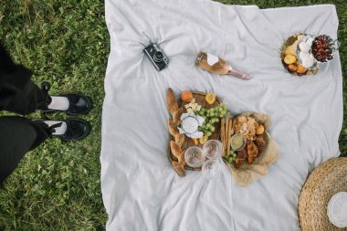 Bir battaniye çimenleri örterken, lezzetli bir piknik de yakınlarda çeşitli yiyecek ve içeceklerle düzenleniyor..