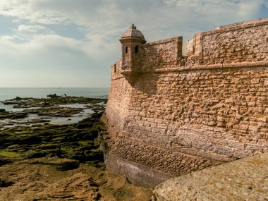 Old castle walls in Cadiz, Spain during cloudy sky