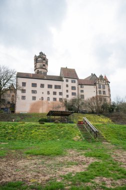 Bulutlu bir günde güzel Ronneburg Şatosu manzarası, öndeki çayır, alçak açı Almanya, dikey çekim