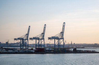 Aarhus Limanı 'ndaki mavi yük vinçleri, günbatımında Danimarka, uzaktan yan görüş