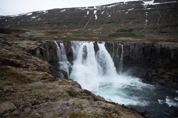 美丽的瀑布落在冰岛的Seydisfjordur 背景是雪山 — 图库照片