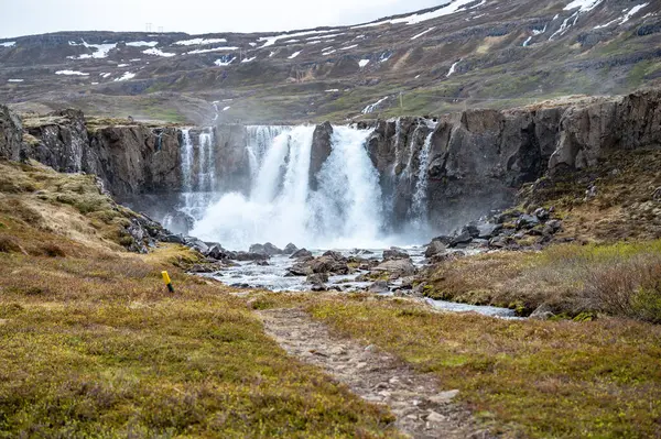 美丽的瀑布落在冰岛的Seydisfjordur 背景是雪山 — 图库照片