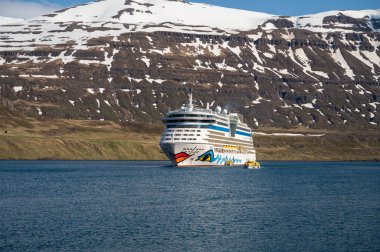 Seydisfjordur, İzlanda fiyordundaki AIDA Bella Cruise Gemisi, kar dağları ile uzaktan arka plan görüntüsü