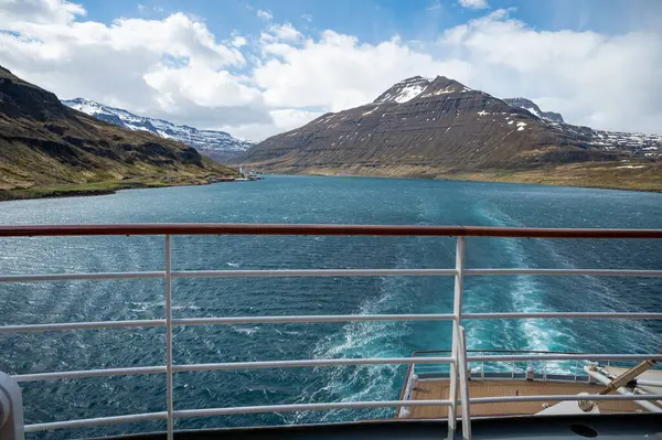 Fjord Von Seydisfjordur Mit Schneebedecktem Gebirge Hintergrund Und Wasser Vorne lizenzfreie Stockfotos