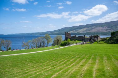 Urquhart Şatosu, Loch ness Gölü, geniş açılı çekim, İskoçya 'daki şatoya giden turistle uzaktan görüş.