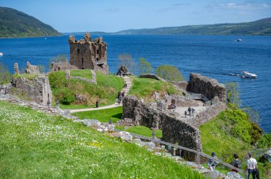 Urquhart Şatosu 'nun hava manzarası. Etrafta bir sürü turist dolaşıyor. Loch Ness, İskoçya.
