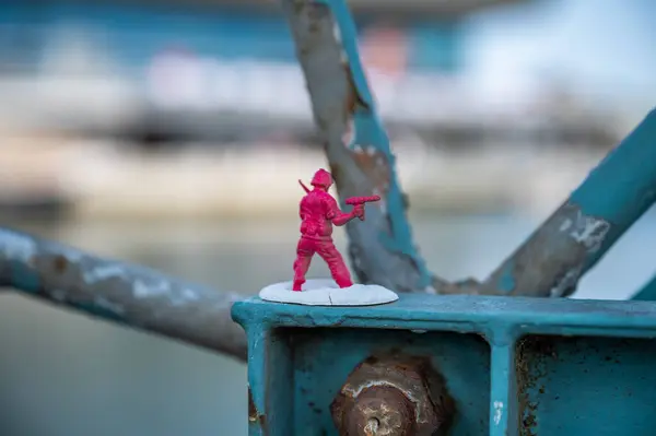 Closeup warrior pink plastic figure attached to metal construction at the Port of Aarhus, Denmark
