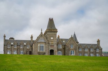 Anderson Enstitüsü, uzaktan tüm bina manzaralı, önünde çayır, Shetland Adası, İskoçya