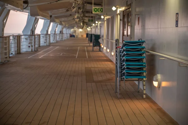 AIDA Bella cruise ship side boat deck with stacked deck chairs in the evening
