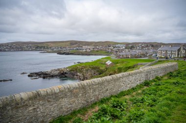 İskoçya, Shetland Adası 'ndaki yerleşim yeri bulutlu bir günde deniz manzaralı, geniş açılı çekim