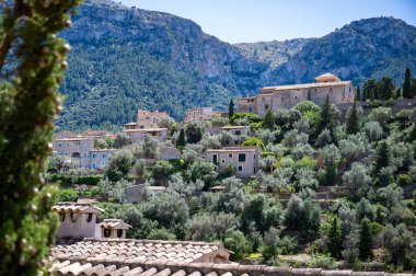 Deia, Mallorca dağ köyü şehir manzarası, arka planda Serra de Tramuntana dağ manzarası, tepedeki binalar, Mayorka İspanya