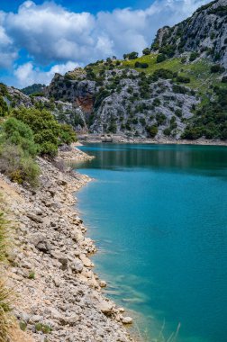 Gorg Blau sanatsal gölü, Mallorca cennet gibi dağ manzarası ve arka planda baraj, dikey çekim, Mayorka