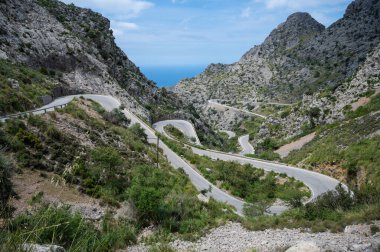 Sa calobra yönünde kıvrımlı yılan yolu, Mallorca dağ manzarası ve arka planda deniz, Mayorka