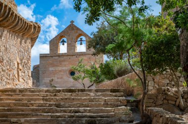 Castell de Capdepera saat kulesi, harika havalarda Mallorca, önde ağaçlar, Mayorka