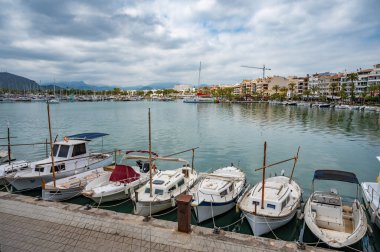 Liman Alcudia, Mallorca Limanı. Limanda küçük balıkçı tekneleri ve gemileri var. Bulutlu bir günde geniş açılı çekim, Mayorka İspanya.