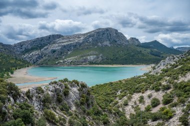 Gorg Blau sanatsal dağ gölü, arka planda dağ silsilesi olan mallorca bulutlu yağmurlu bir günde, Mayorka İspanya