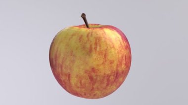 Sade bir zeminde dönen canlı kırmızı ve sarı elma