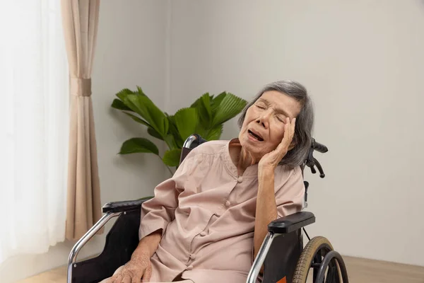 アジア系の高齢者の女性が眠っている 老人ホームで車椅子の上で雪 — ストック写真