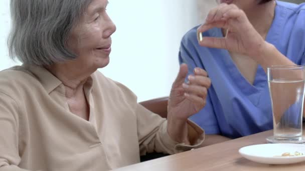 Vårdgivare Fiskolja Till Äldre Kvinna Pensionärshuset — Stockvideo