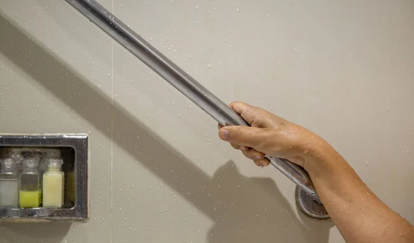 浴室の安全のための手すりに保持するシニア女性 ロイヤリティフリーのストック画像