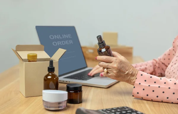 Senior woman sell items online and make money in retirement.