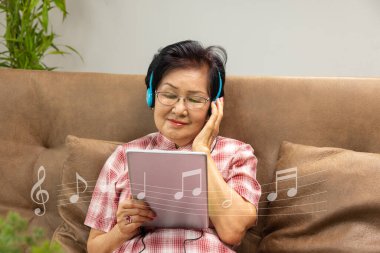 Sunbae, kanepedeki bilgisayar tabletinden müzik dinle..