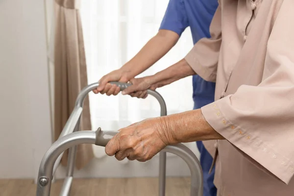 照顾者带走的是患Sarcopenia或肌肉萎缩的老妇人 日光浴是一种变性的肌肉疾病 通常是由衰老的自然后果引起的 — 图库照片
