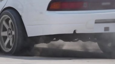 Sürüklenen araba hız yolunda lastikleri yakıyor.