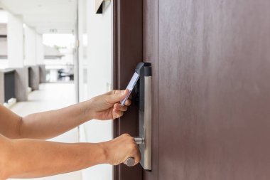 Kapıyı açmak için elektronik kart kullanan bir kadın..