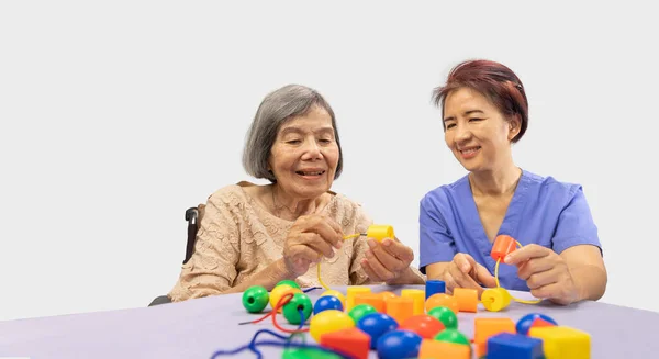 照顾者和老年妇女玩木制字谜游戏预防痴呆症 — 图库照片