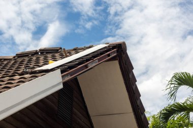 Tamirci çatıdaki saçakları yapay ahşapla değiştiriyor..