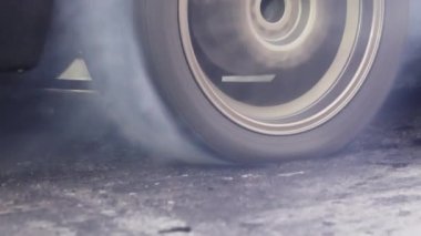 Sürüklenen araba hız yolunda lastikleri yakıyor.