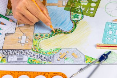 Peyzaj mimarı öğrenci bahçe planını elle çizerek öğreniyor..