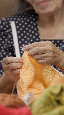 Elderly woman knitting for protect dementia and memory loss. clipart