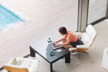 Phuket 'teki lüks villada çalışan kıdemli dijital göçebe kadın. Arka plan olarak anadman denizi.