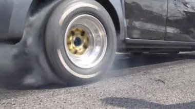 Yarış pistinde kalkış çizgisinde yarış arabasının lastiği yanıyor.