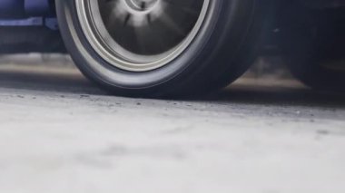EV kalkış yarışı arabası başlangıç çizgisinde patinaj çekiyor..