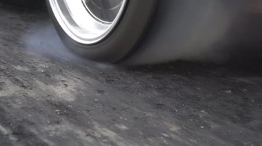 EV kalkış yarışı arabası başlangıç çizgisinde patinaj çekiyor..