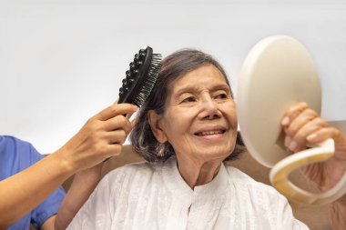 Yaşlı kadın caregiver tarafından saç tarak