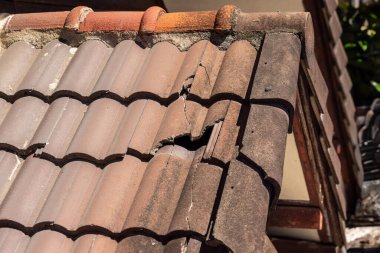 Tamire ihtiyacı olan hasarlı eski çatı kiremiti.