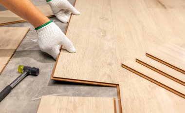 Worker Installing Interlocking laminate floor, home renovation.