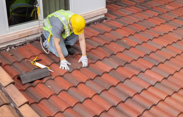 stock image Construction worker is inspecting roof tile cracked.