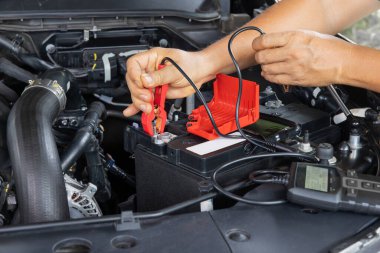 Adam, AG M bataryalarının gücünü evde pil testi yaparak ölçüyor..