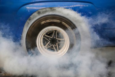 Yarış arabası başlangıç çizgisinde lastikleri yakıyor..