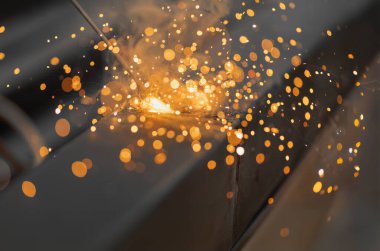 worker welding steel pipe in construction site.