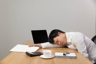 Man with narcolepsy is fall asleep on office desk clipart