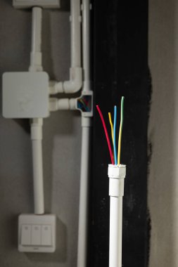 Electrician open cap of PVC inspection tee fitting on wall