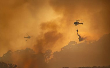 İtfaiye helikopteri orman yangınını söndürmek için Watthar kovası taşıyor..